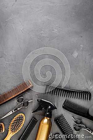 Hairdresser set in beauty salon. Combs, scissors, spray on grey desk top-down copy space Stock Photo