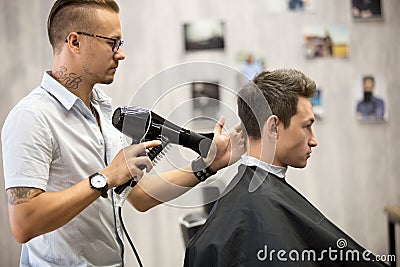 Hairdresser styling hair for male client Stock Photo