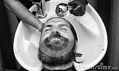 Hairdresser washes client man head in barbershop, hair care Stock Photo