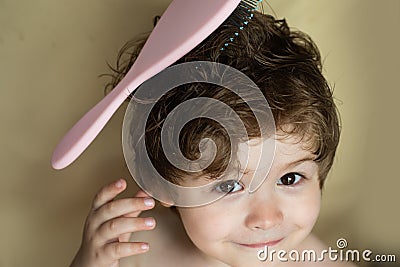 Hairstyle for a child. Baby with a comb. Stylish boy. Combing hair. Barbershop. Beauty saloon. Cute kid with wet hair Stock Photo