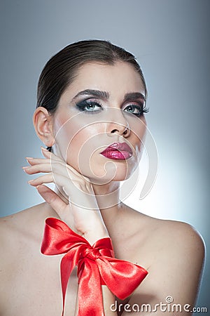 Hairstyle and Make up - beautiful female art portrait with red ribbon. Elegance. Genuine Natural brunette with ribbon - studio Stock Photo