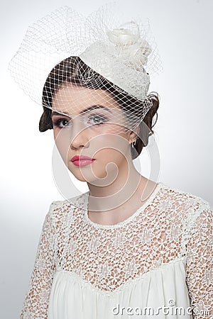 Hairstyle and make up - beautiful young girl art portrait. Cute brunette with white cap and veil, studio shot. Attractive girl Stock Photo
