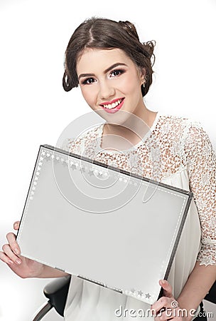 Hairstyle and make up - beautiful young girl holding a white paper in her hands. Genuine natural brunette, studio shot Stock Photo