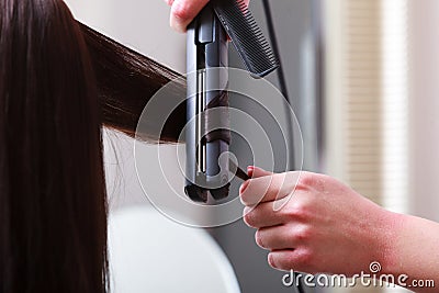 Hairstylist curling hair woman client in hairdressing beauty salon Stock Photo