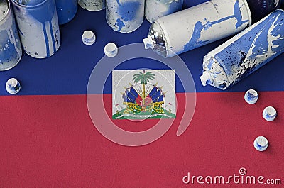 Haiti flag and few used aerosol spray cans for graffiti painting. Street art culture concept Stock Photo