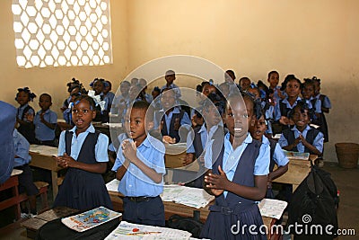 Haitian school children welcome visitors in their classroom. Editorial Stock Photo