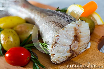 Tail of hake by rustically frying and served with boiled potatoes and tomatoes Stock Photo