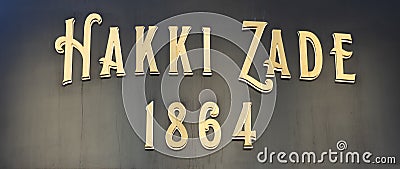 Hakki Zade was established in 1864 as a confectioner. Hakki Zade sign photographed nearby. Gold color on black surface Editorial Stock Photo