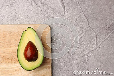 Half avocado with seed on wooden board. avocado on cement top view Stock Photo