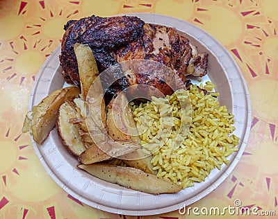 Half barbecue chicken with yellow rice and potato wedges Stock Photo