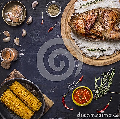 Half chicken with rice on a cutting board with spices, corn and herbs, place for text,frame wooden rustic background top view Stock Photo