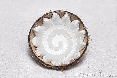 Half coconut lying in white sand Stock Photo