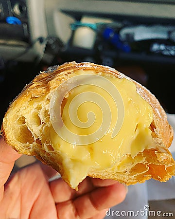 half croissant, croissant stuffed with cream, dessert , egg custard in croissant, pastry with lots of filling Stock Photo