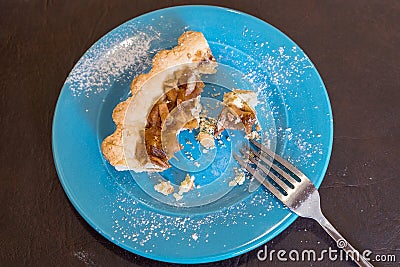 Half eaten slices of cake on a plate with crumbs and a fork Stock Photo