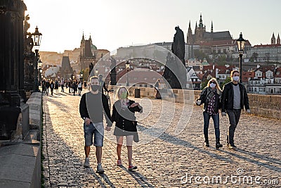 Half-empty Charles Bridge in Prague during coronavirus pandemic, with people wearing face masks Editorial Stock Photo