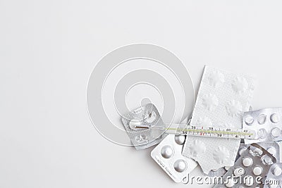 Packs of medicines with an old mercury thermometer on a white background. Top view Stock Photo