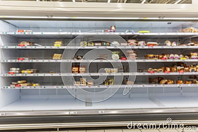 Half empty supermarket shelves with chilled smoked meat delicacies. Popular unhealthy foods. Front view Stock Photo