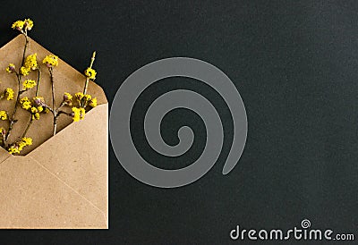 Half of the envelope of eco paper with yellow flowers on black background. Stock Photo
