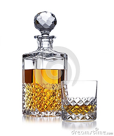 A half full crystal whisky decanter, and crystal glass, with golden whisky, shot on white Stock Photo