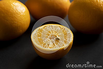 Half of the lemon lies in front of the rest of the lemons Stock Photo