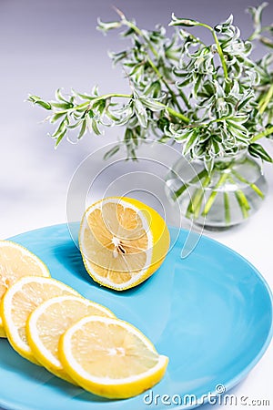 Half a lemon and slices on a blue plate Stock Photo