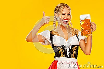Wow emotion, woman with thumbs up. Young sexy Oktoberfest girl waitress, wearing a traditional Bavarian or german dirndl Stock Photo