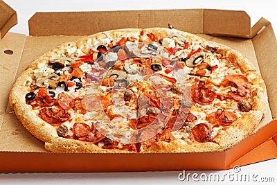 Half meat and half vegetable pizza on white wooden table. Angle view. Stock Photo