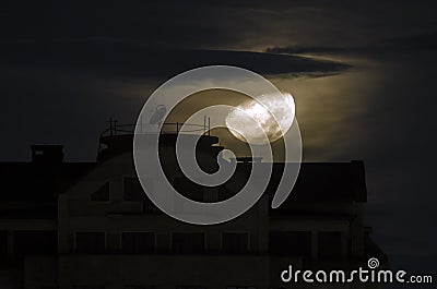Half moon goes down near the building at night. Close up view of real half moon in Baku Azerbaijan. Big half moon shining bright n Stock Photo