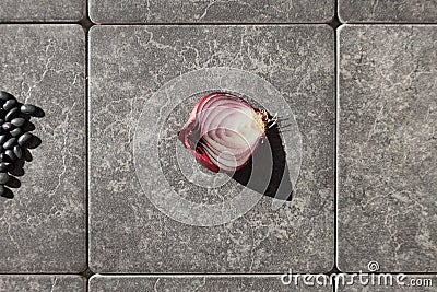 Half onion on gray tiles Stock Photo