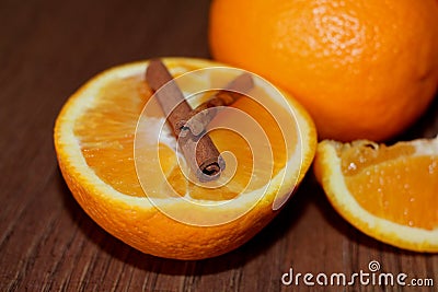 Half a juicy orange with cinnamon sticks on a wooden Board Stock Photo