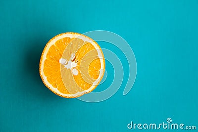 Half of orange on turquois background with copy space Stock Photo
