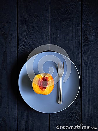 Half peach and fork on the plate Stock Photo