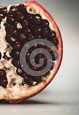 Half pomegranate on a blue background close-up. Ripe pomegranate seeds Stock Photo