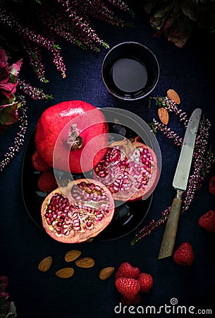 Half pomegranate and knife and cup Stock Photo