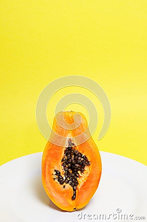 Half of ripe papaya on yellow Stock Photo