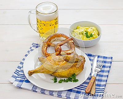 Half roast chicken, beer, pretzel and potato salad Stock Photo