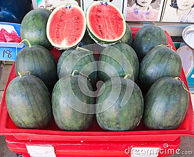 Half sliced watermelon wrapped protective film sold at local farm market Stock Photo