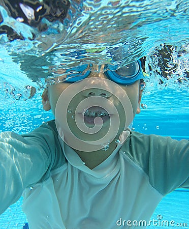 Half submerged 4 year old asian boy playing in pool Stock Photo