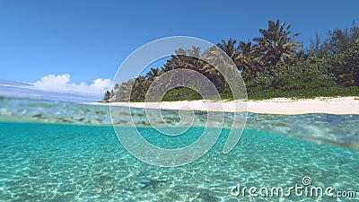 HALF UNDERWATER: Paradise beach is swept by the tranquil crystal clear sea. Stock Photo