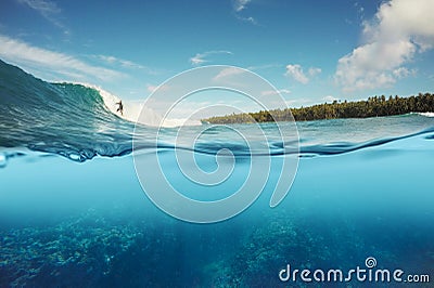 Half underwater shot of surfer surfing a wave in Indo Stock Photo