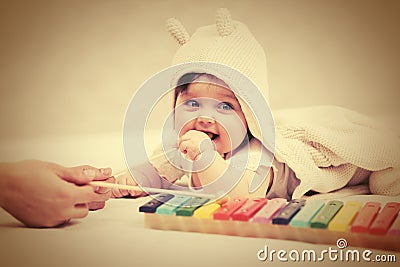 Half year baby girl playing with xylophone toy on blanket Stock Photo