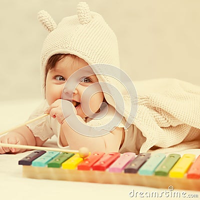 Half year baby girl playing with xylophone toy on blanket Stock Photo