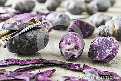 Halfed and whole peeled and unpeeled purple potatoes Stock Photo