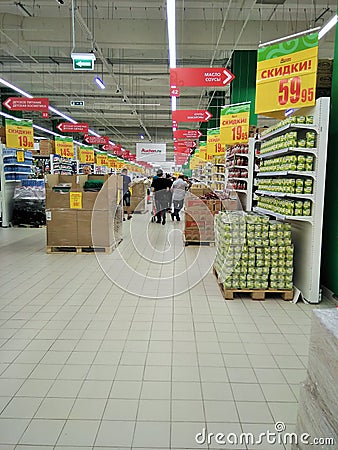 Hall large supermarket with notifications of discounts and sales, shelving products Editorial Stock Photo