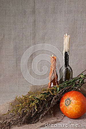 Halloween autumn still life. Pumpkin, candles in bottles, herbs. Light canvas background. e. Stock Photo
