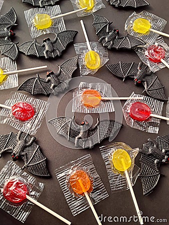 Halloween bats and candy suckers on a black background Stock Photo