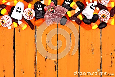 Halloween candy top border over old orange wood Stock Photo