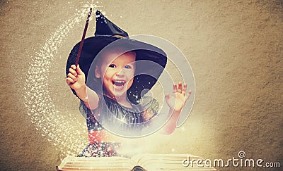 Halloween. cheerful little witch with a magic wand and glowing b Stock Photo