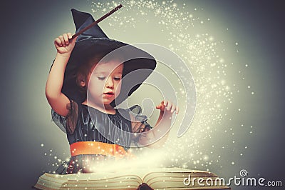 Halloween. cheerful little witch with a magic wand and glowing b Stock Photo