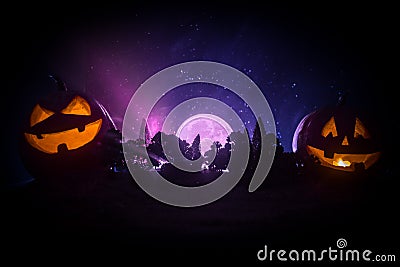 Halloween concept with glowing pumpkins. Strange silhouette in a dark spooky forest at night, mystical landscape surreal lights wi Stock Photo
